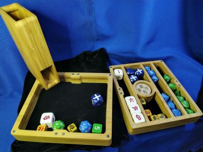 So, I bragged about this elsewhere (MeWe) but this is probably a better-focused place for it.

Meet my dice tower/dice storage tray of doom.  (Not depicted is the extra spacer in the tower portion that widens the slot sufficiently that I can roll d24s, d30s, and some oversized Chinese drinking game dice I have.)

It's made almost entirely of bamboo, has a felt underlay for where the dice roll (or get stored), is held together when packed up by magnets (and indeed magnets are what's holding the dice tower in the corner) and packs up into a small, easily-carried box.